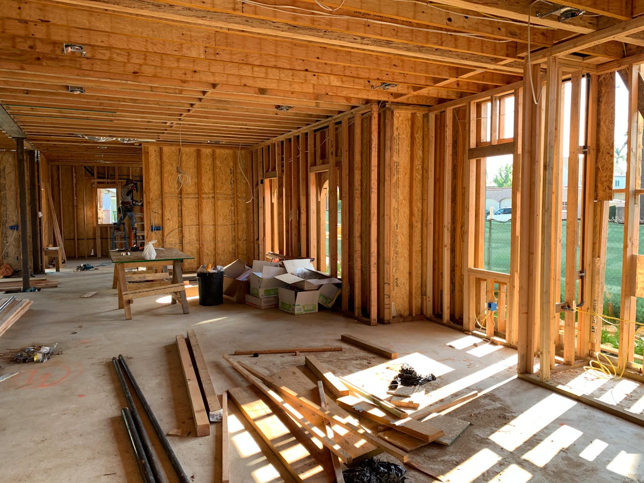 Home Sunlit interior with wood framing, showcasing home construction progress.