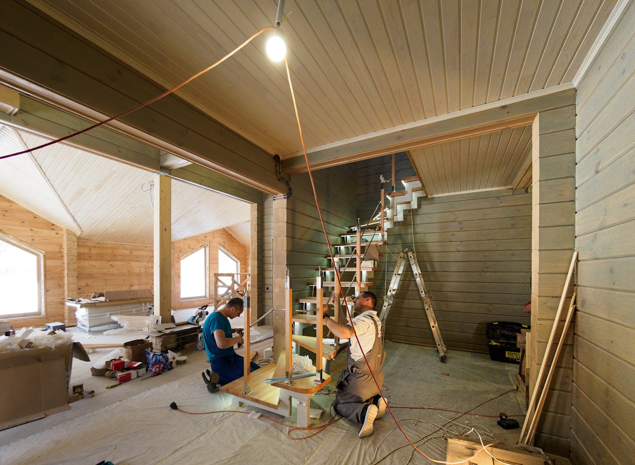Home Carpenters skillfully assembling a modern wooden staircase inside a newly constructed home interior.